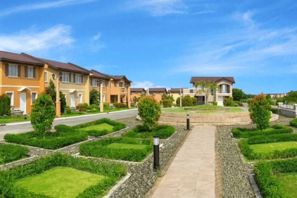 Street view of a residential area with manicured lawns and colorful houses.