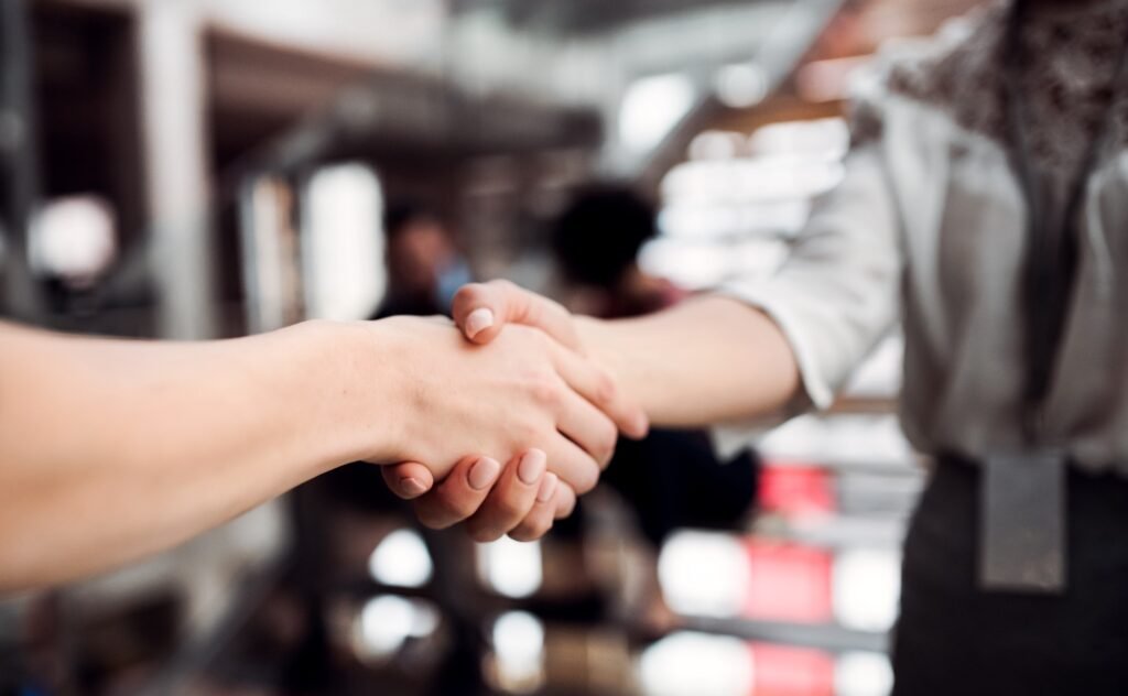 A midsection of young businesswomen, shaking hands.