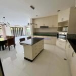 A bright, open-plan kitchen and dining area with modern furnishings.