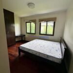 Bedroom with a bed, wardrobe, desk, and two windows.