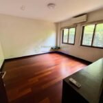 A bright, empty room with wood floors and two windows.