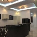 A modern kitchen with black marble countertops and sleek appliances.