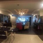 A modern home interior with a dining table, staircase, and chandelier.