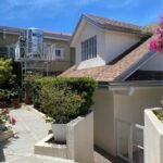 Exterior view of a house with a water tank and garden area.
