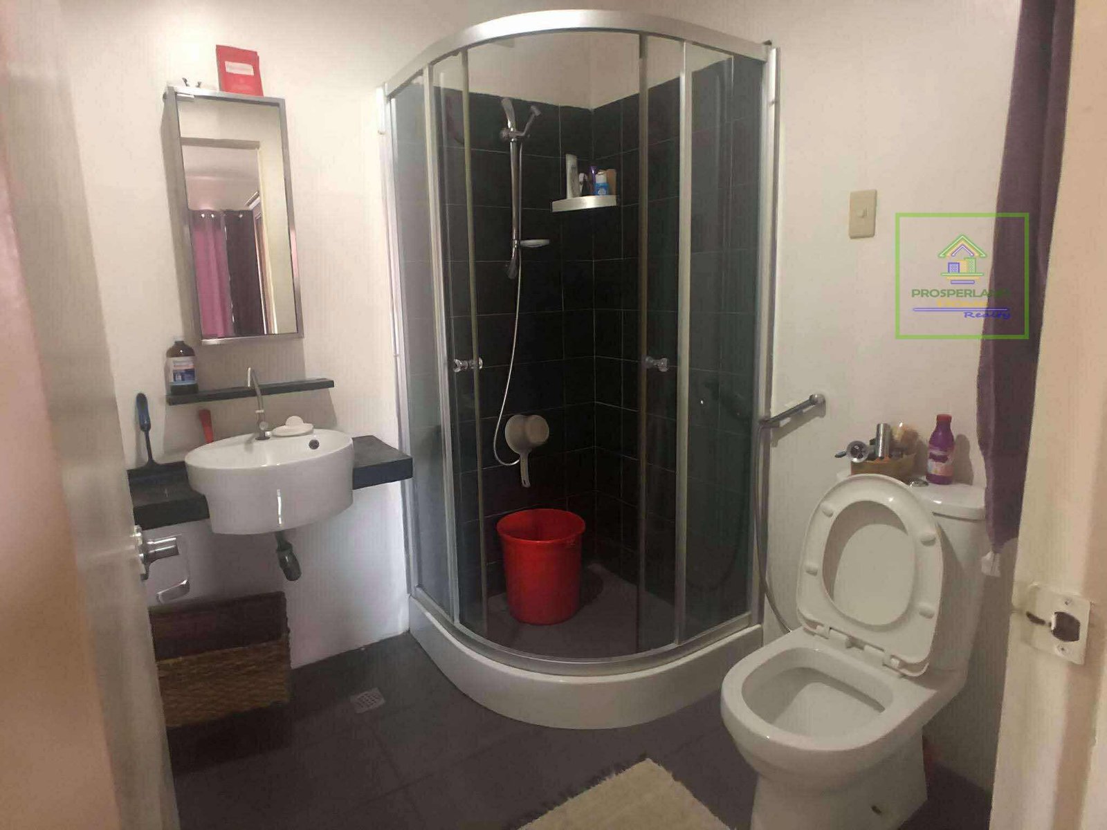 A bathroom interior with a glass shower, sink, and toilet.