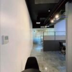 A view into an office space with a black chair in the foreground.