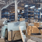 A warehouse storing window glass with Prosperland Realty logo.