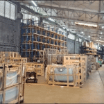 A warehouse with glass products stored in crates on shelves.