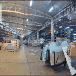 A large industrial warehouse interior filled with crates and materials.