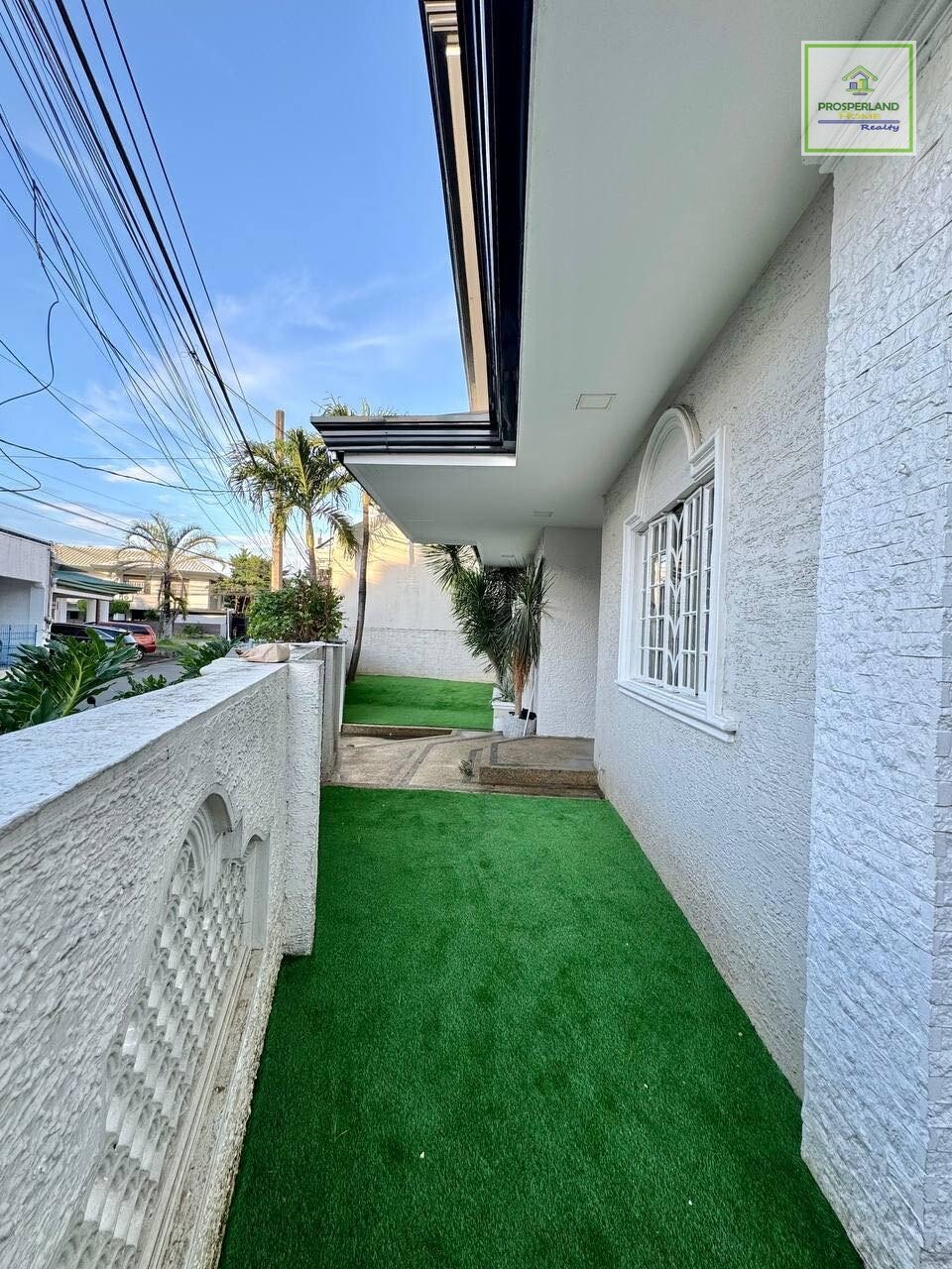 Side view of a house exterior with a small green lawn.